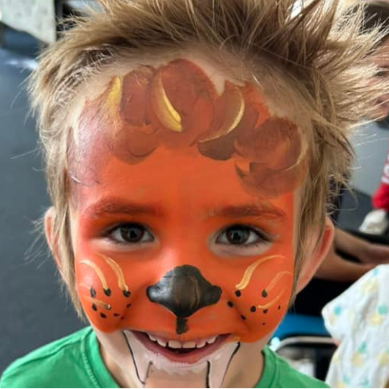 Child with face painted as lion